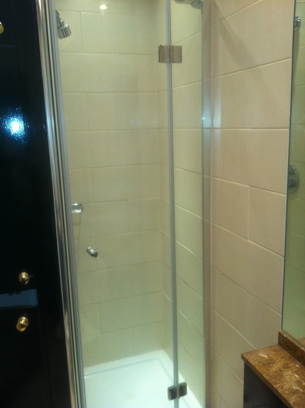 Frameless glass shower enclosure with chrome fittings in Norbury