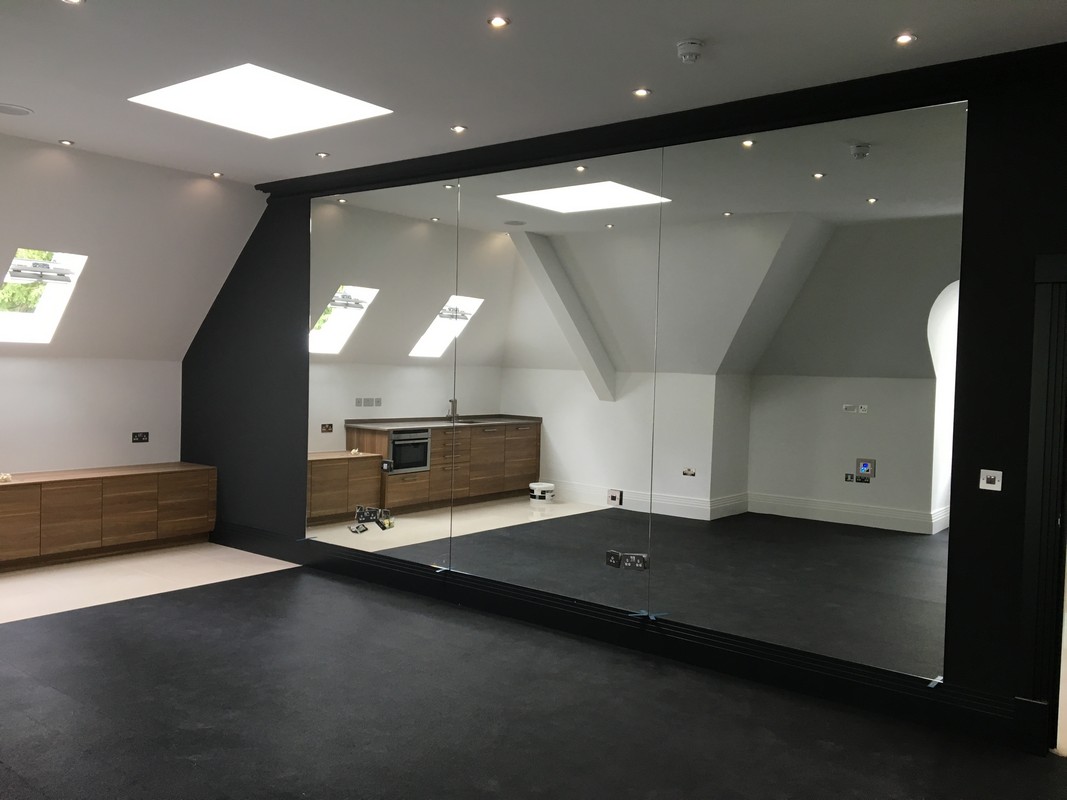 Frameless glass wall dividing loft conversion in Norbury